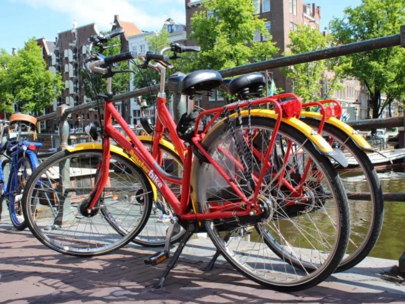Two red Amsterbike bikes besides the canals of Amsterdam